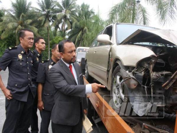 Adnan (kanan) memeriksa kenderaan yang digunakan untuk menyeludup minyak petrol.