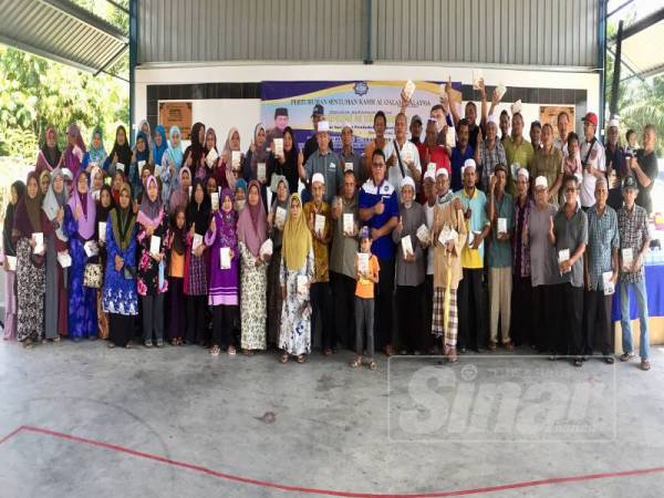 Baharudin (depan, sebelas dari kanan) bergambar bersama penerima wang zakat sumbangan Pertubuhan Sentuhan Kasih Al-Qalam Malaysia hari ini.
