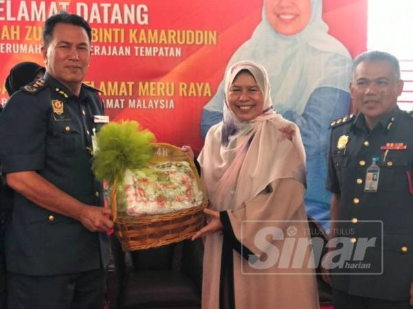 Zuraida menyampaikan sumbangan berupa telekung, kurma dan bubur lambuk kepada Azmi (kiri) pada program bersama warga JBPM Perak di Balai Bomba dan Penyelamat Meru Raya hari ini.