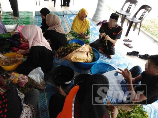 Pelatih bersama penduduk kampung bekerjasama menyediakan bahan untuk memasak bubur lambuk.
