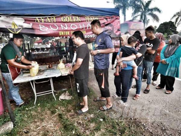 Pelanggan beratur panjang sabar menunggu giliran untuk membeli ayam golek madu Bunohan di Batu 8.