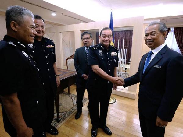 Menteri Dalam Negeri Tan Sri Muhyiddin Yassin (kanan) bersalaman dengan Timbalan Ketua Polis Negara yang baharu Datuk Mazlan Mansor (dua, kanan) ketika menerima kunjungan hormat Timbalan Ketua Polis Negara di Kementerian Dalam Negeri hari ini. - Foto Bernama