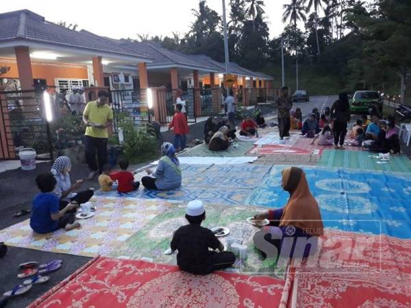 Penduduk memilih untuk duduk bersila di atas tikar yang dihamparkan di atas jalan di luar rumah masing-masing yang jelas menyerlahkan semangat kejiranan mereka.