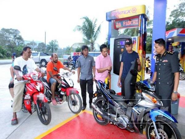 Mohd Khairuddin (empat, kanan) beramah mesra bersama penduduk kampung ketika Majlis Pelancaran Stesen Minyak Mini Smart Stream di Felda Sungai Panching Selatan, di sini hari ini.