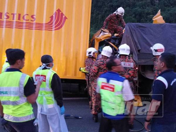 Pasukan bomba membantu mengeluarkan mayat mangsa yang tersepit di tempat duduknya selepas terbabit dalam nahas di Kampar, hari ini. 