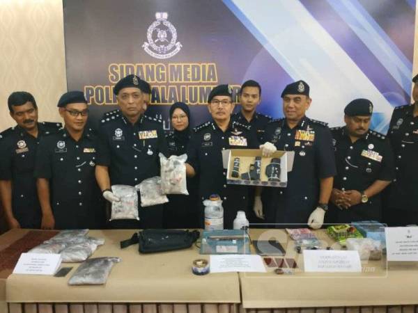 Ketua Polis Kuala Lumpur, Datuk Seri Mazlan Lazim ( tengah) menunjukkan pistol dan dadah serta barangan yang dirampas polis dalam tiga serbuan yang dilakukan oleh Jabatan Siasatan Jenayah Narkotik, Ibu Pejabat Polis Daerah Sentul ketika ditemui pada sidang media di Ibu Pejabat Polis Kontinjen Kuala Lumpur hari ini.