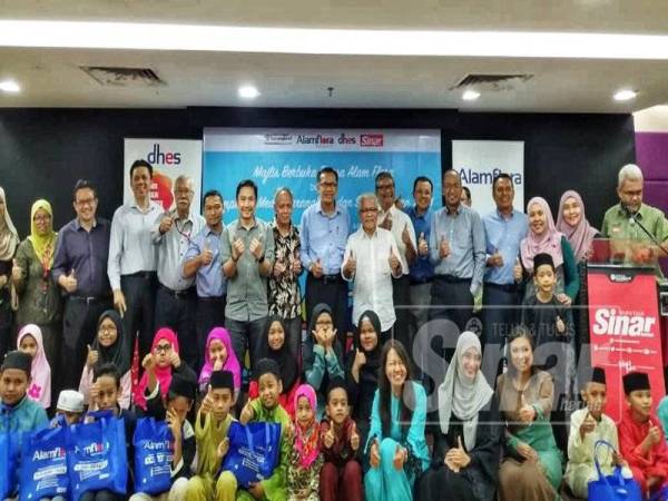 Mohd Zain (tengah, berdiri) bergambar bersama barisan pengurusan Karangkraf dan Alam Flora serta anak-anak yatim dan asnaf yang diraikan pada majlis berbuka puasa di bangunan Karangkraf, hari ini.