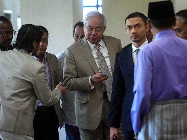 Najib ketika keluar rehat sebentar di luar mahkamah pada hari ke-18 perbicaraan berhubung kes penyelewengan SRC International Sdn Bhd, yang dihadapinya di Kompleks Mahkamah Kuala Lumpur hari ini. - Foto Bernama