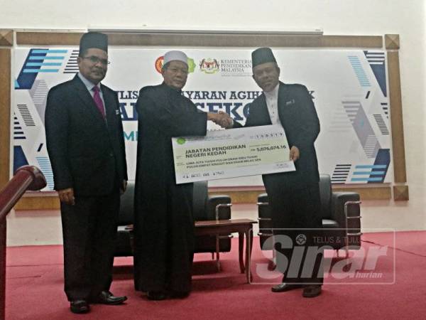 Syeikh Fadzil (tengah) menyerahkan cek agihan balik zakat kepada Mohd Syauqi (kanan) sambil diperhatikan Syeikh Zakaria (kiri) dalam Majlis Penyerahan Pembayaran Agihan Balik Zakat Sekolah Seluruh Kedah di Maktab Mahmud Alor Setar hari ini.