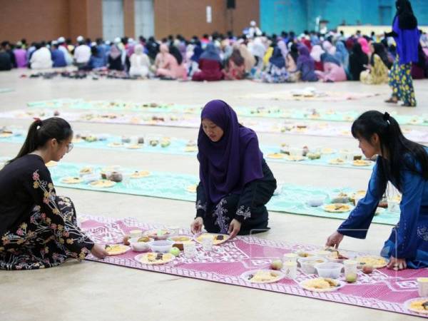 Shuni dan Ooi Qian Yi membantu menghidang makanan sempena Program Iftar Kubra UniMAP 2019 di Dewan Ilmu, Kampus UniMAP di sini semalam.