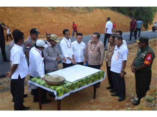 Presiden Jokowi bersama beberapa pegawai melihat peta ketika melakukan lawatan ke Gunung Mas di Kalimantan Tengah pada 8 Mei lalu. - Foto Antara