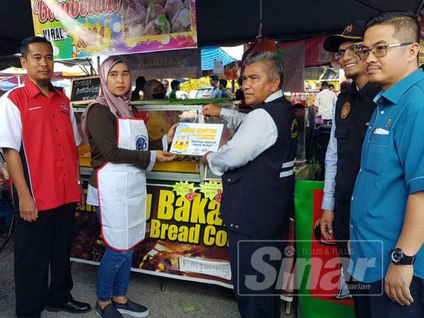 Mohd (tiga dari kanan), Ahmad Nazwawi (kanan) dan Mohd Anuar (dua dari kanan) menyampaikan Anugerah Gerai Contoh kepada peniaga di Bazar Ramadan Jalan Padang sempena pelancaran Kempen Kebersihan dan Keselamatan Makanan Bazar Ramadan.