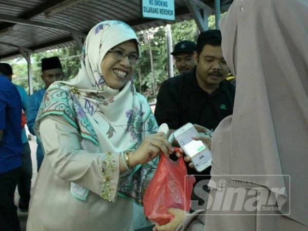 Rodziah (dua, kanan) mengedarkan 'bubur lambuk Batu Tiga' kepada orang awam di sekitar DUN Batu Tiga. berjaya dibongkar pihak berkuasa