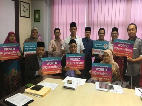 Abdul Halim (duduk kiri) memgang plakad World #QuranHour sebagai tanda sokongan terhadap penganjuran program itu pada sidang media di Melaka kelmarin.
