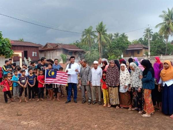 Mustapha (tengah baju putih) bersama Sren Meen (baju kelabu) dan sebahagian penduduk kampung di tapak yang akan dibina masjid baharu bagi kampung tersebut.