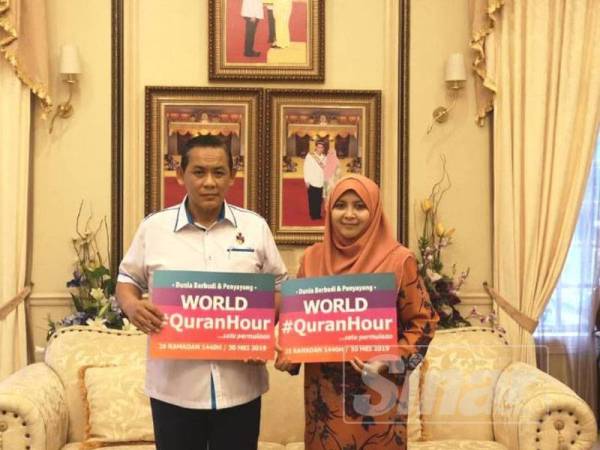 Aminuddin dan isteri, menunjukkan tanda sokongan terhadap World #QuranHour.