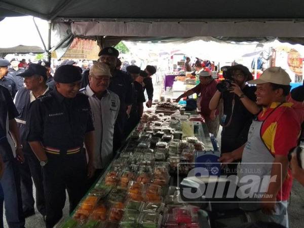 Razaruddin melihat makanan yang dijual di salah satu gerai di Bazar Ramadan Medan Gopeng sempena program HPP Polis Perak.