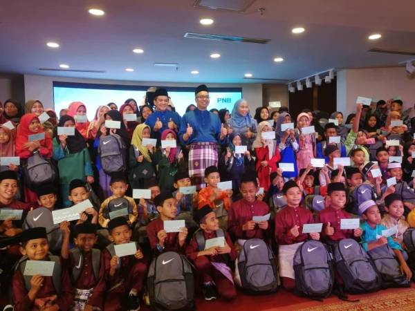 Abdul Rahman bergambar dengan 150 anak yatim pada Majlis Berbuka Puasa PNB bersama 150 anak yatim dari empat rumah kebajikan di Menara PNB Jalan Tun Razak di Kuala Lumpur, semalam.