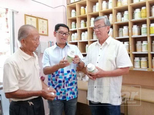 Ahmad Faizal (tengah) melihat bekalan ubat yang terdapat di Pusat Pemeriksaan Kesihatan Persatuan Penganut Agama Buddha Temoh.