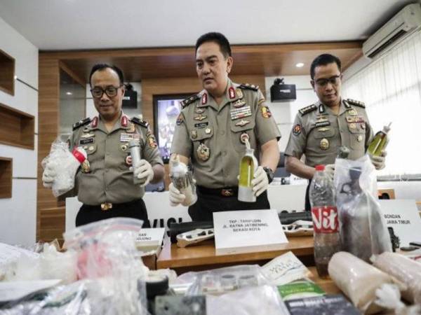 Muhammad Iqbal (tengah) menunjukkan bahan bukti yang dirampas ketika sidang media di Jakarta semalam. 