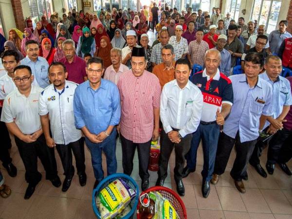 Menteri Perdagangan Dalam Negeri dan Hal Ehwal Pengguna (KPDNHEP) Datuk Seri Saifuddin Nasution Ismail (empat, kiri) bergambar bersama para penerima bantuan keperluan makana harian Program Ihya Ramadan Menteri KPDNHEP bersama warga komuniti pengguna jajahan Tumpat di Pertubuhan Peladang Kawasan Bakat Baru, Kampung Paloh, Wakaf Bharu, hari ini. - Foto Bernama