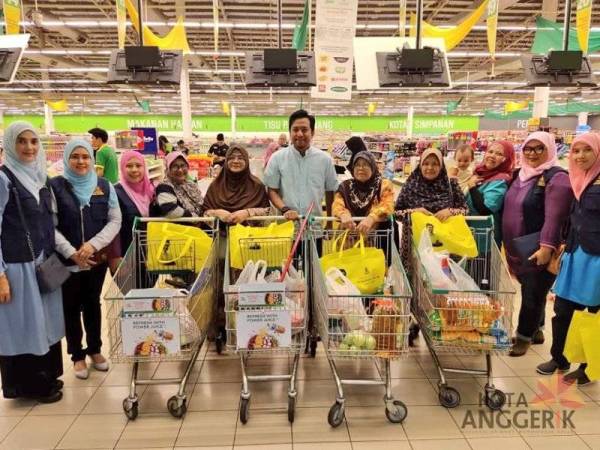 Mohd Najwan (tengah) meraikan penerima baucar Jom Shopping dengan menemani mereka membeli-belah di Giant Seksyen 13, di sini.