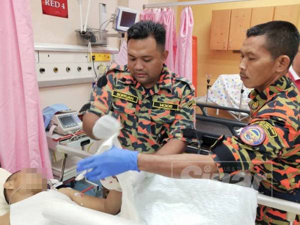 Anggota bomba sedang memotong cincin di jari mangsa bagi memudahkan rawatan dilakukan pihak hospital.