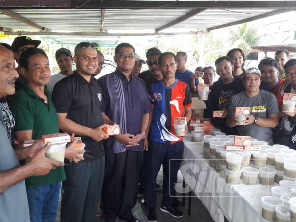 Dzulkefly (empat, kiri) bergambar sempena Program Masak Bubur Lambuk dan Penyampaian Sumbangan kepada Asnaf di Taman Nusantara, di sini hari ini. 