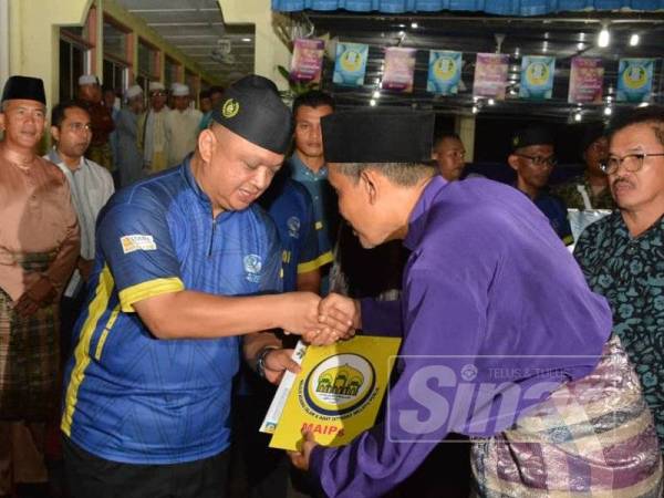 Syed Faizuddin menyampaikan sumbangan daripada MAIPs kepada imam Masjid Hidayatul Iman, semalam.