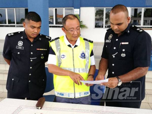 Omar Bakhtiar(tengah) meneliti kandungan laporan soal-siasat kedua suspek ditahan berhubung kes kemalangan kereta 'sardin' membabitkan 16 penumpang di Bukit Merah, semalam.