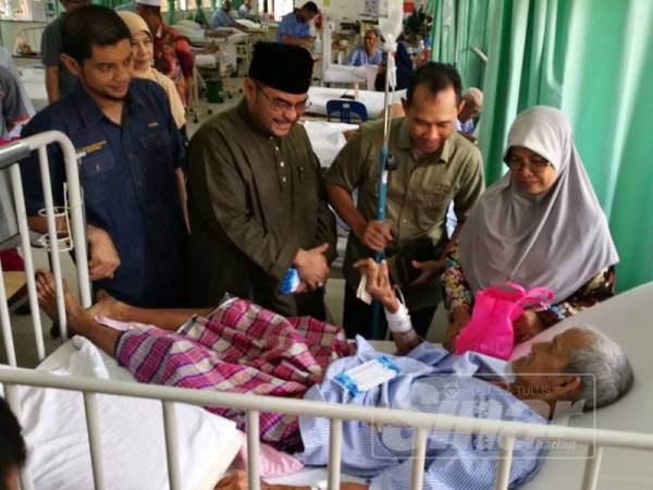 Hasnul Zulkarnain (kiri) mengiringi Mujahid (dua dari kiri) menyerahkan sumbangan duit raya kepada pesakit di wad lelaki Hospital Parit Buntar.