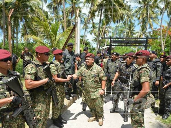 Syed Faizuddin bersalaman dengan anggota yang bertugas di Pulau Siamil ketika lawatannya di pulau berkenaan, semalam.