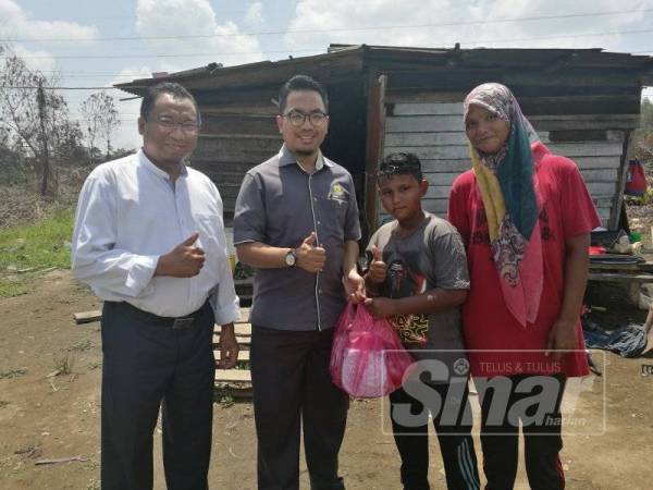 Mohd Shukri (dua, kanan) bersama ibunya, Nor Azuha menerima murtabak ferry yang disampaikan oleh Mohd Aminur (dua, kiri) diiringi Mohd Rashimi ketika menemui keluarga tersebut di rumahnya di Permatang Badak di sini, hari ini.