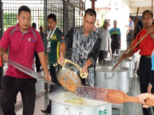 Ahli KESKA UUM bergotong royong memasak bubur lambuk untuk diagihkan kepada orang ramai. - FOTO UUM