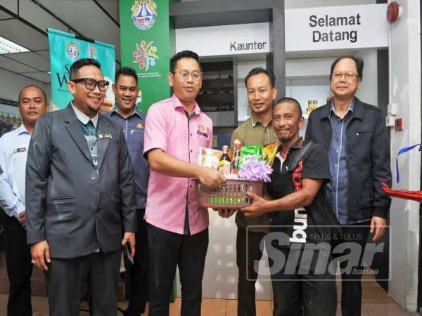 Mohd Hafiz (tengah) menyerahkan sumbangan Sudut Wakaf kepada Abdul Rahim (dua dari kiri) di MDYP.