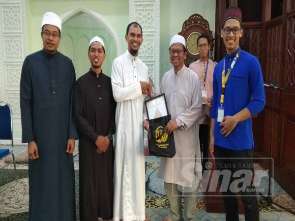 Asmuni (dua, kanan) menerima cenderahati daripada Penasihat Utama YDKMM, Dr Mohd Hizul Azri Md Noor selepas menyempurnakan pelancaran program berkenaan di Masjid Sultan Idris Shah ll (Masjid Negeri Perak) di sini.