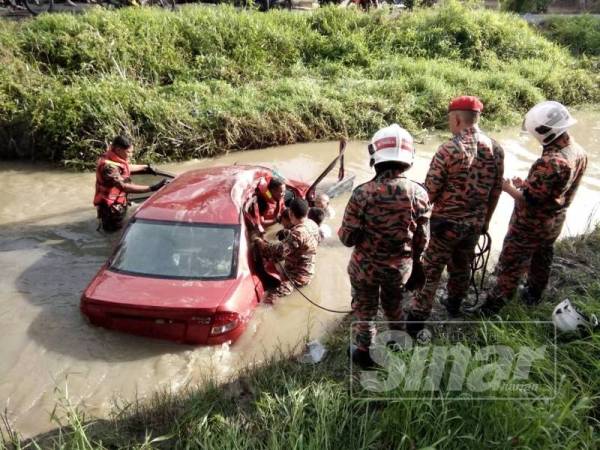 Anggota bomba mengeluarkan mangsa dari kereta.