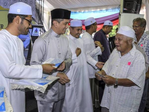 Datuk Seri Mohamed Azmin Ali (dua, kiri) menyampaikan sumbangan kepada golongan asnaf pada Majlis Iftar Perdana dan Penyerahan Sumbangan Hari Raya Aidilfitri di Surau Jabal Nur Sri Gombak Hari ini. Foto: Bernama