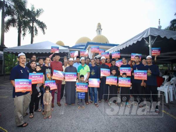 Ahli Pertubuhan Seni Silat Pusaka Gayong Malaysia Damansara Damai bersama penduduk sekitar memegang plakad World #QuranHour tanda sokongan kepada program itu di Damansara baru-baru ini. - FOTO: ZAHID IZZANI