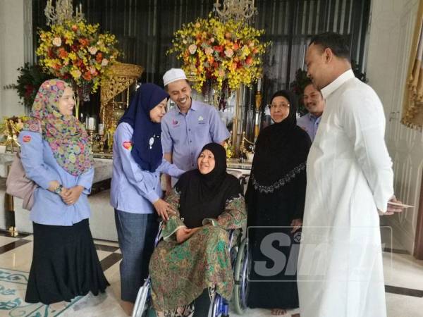 Khatijah berkerusi roda meluahkan rasa rindunya pada Allahyarham Faziani ketika dikunjungi Pengarah Pertubuhan Keselamatan Sosial (PERKESO) Kelantan, Nora Yaccob (kiri).