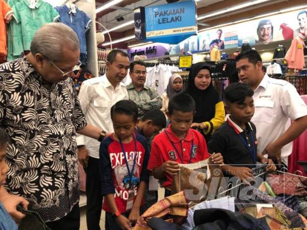 Annuar membantu memilih baju raya 122 kanak-kanak di Pasaraya Mydin Kubang Kerian hari ini.