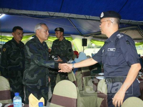 Acryl Sani (dua,kiri) bersalaman dengan Hasanuddin (kanan) pada Majlis Iftar Ramadan bersama anggota PGA di Markas Taktikal PGA Lubok Stol, semalam.