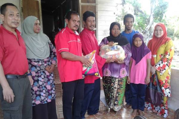 Fauzi Long (empat dari kiri) menyampaikan sumbangan kepada Hasnaf di Kampung Pandu di sini.