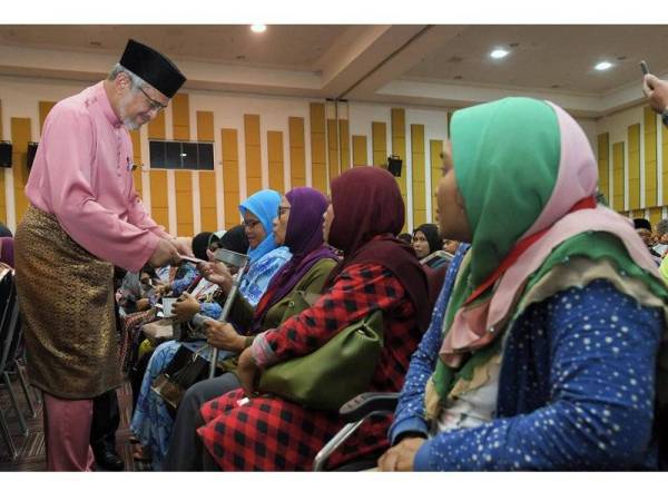 Menteri Wilayah Persekutuan Khalid Abdul Samad (kiri) menyampaikan sumbangan kepada sebahagian penerima pada Majlis Sumbangan Aidilfitri Komuniti Kuala Lumpur di Dewan Perdana Mestika Institut Latihan DBKL hari ini.