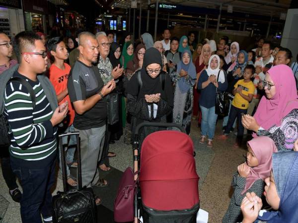 Ibu bapa Ainul Mardhiah, Ahmad Safiuddin Ahmad Razak (depan kiri) dan isteri Nurul Erwani Zaidi diiringi sebahagian anggota keluarga yang mengiringi perjalanan mereka ke London malam tadi. - Foto Bernama 