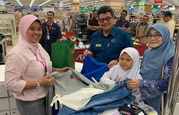 Mohd Azhar (tiga, kanan) bergambar bersama salah seorang penerima dalam program berkenaan.