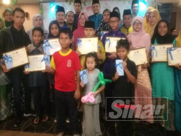 Fadhilah (tengah) bersama sebahagian anak angkat di bawah Perkeso yang diraikan dan menerima sijil anak angkat dalam satu majlis di satu majlis di Hotel Sentral Riverview, di sini, malam tadi.
