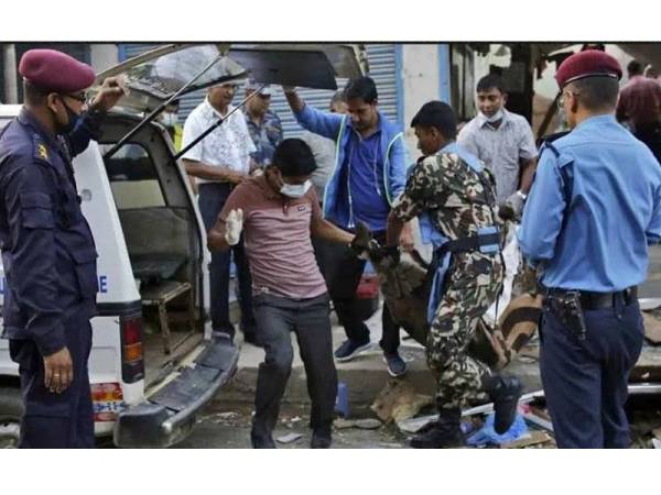 Mayat salah seorang mangsa yang maut dibawa keluar dari lokasi insiden letupan di Kathmandu. - Foto AP