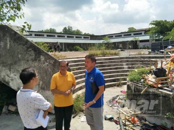 Lawrence (kanan) berbincang bersama Raymond (kiri) sewaktu meninjau lokasi pasar terbabit.