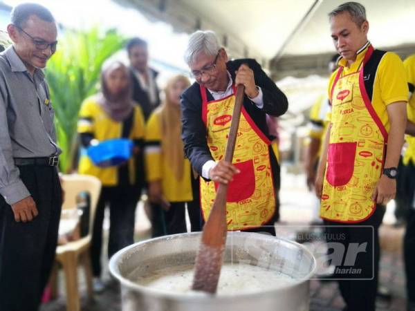 Abdul Aziz mengacau bubur lambuk sempena program berkenaan.